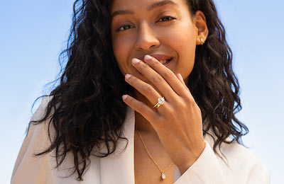 Model smiling wearing a variety of wedding jewelry 