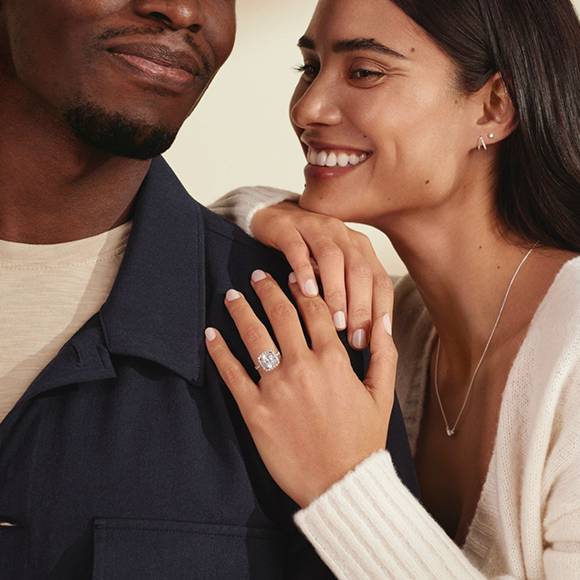 Couple showing off halo engagement ring