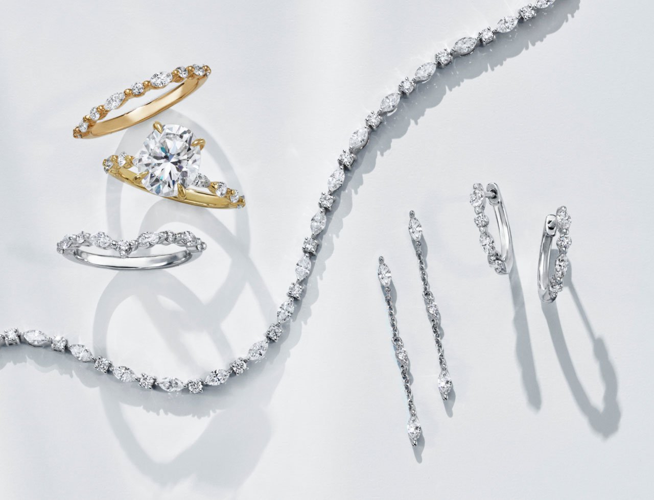 Diamond engagement ring, wedding rings, and assortment of fine jewelry from Brilliant Earth's Versailles collection.