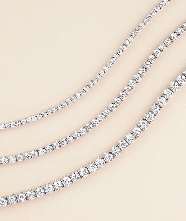 Lustrous white gold diamond tennis bracelets in different total carat weights.