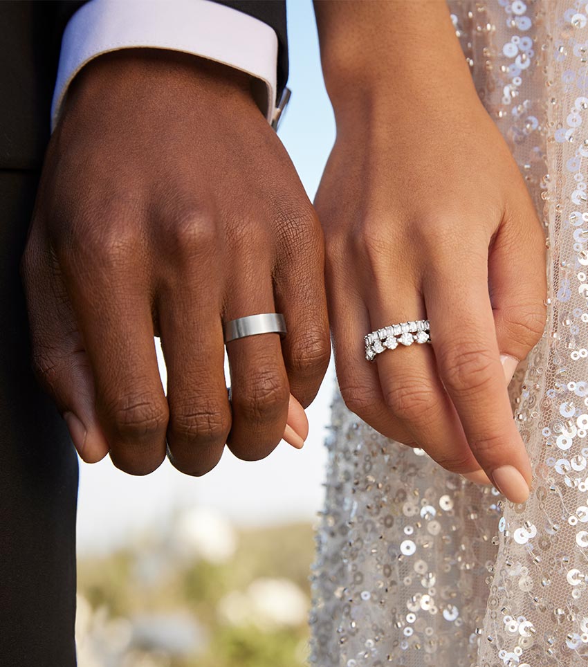 Couple wearing a wedding band and a diamond wedding ring