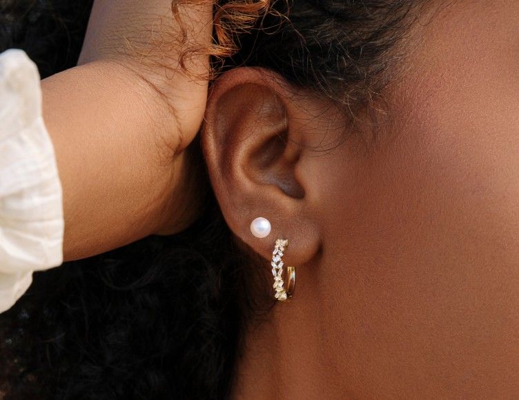 Gold diamond hoop earrings and pearl stud earrings.