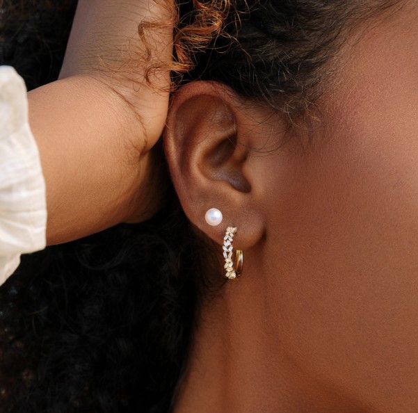 Gold diamond hoop earrings and pearl stud earrings.