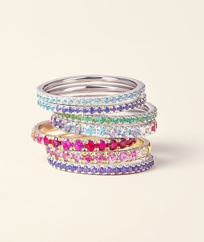 Assortment of colorful gemstone rings stacked