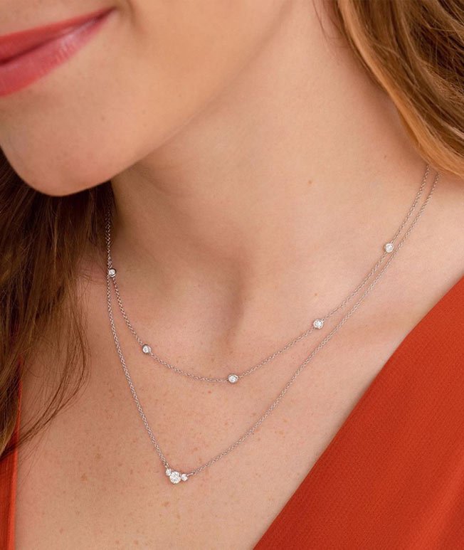 Woman wearing layered diamond necklaces.