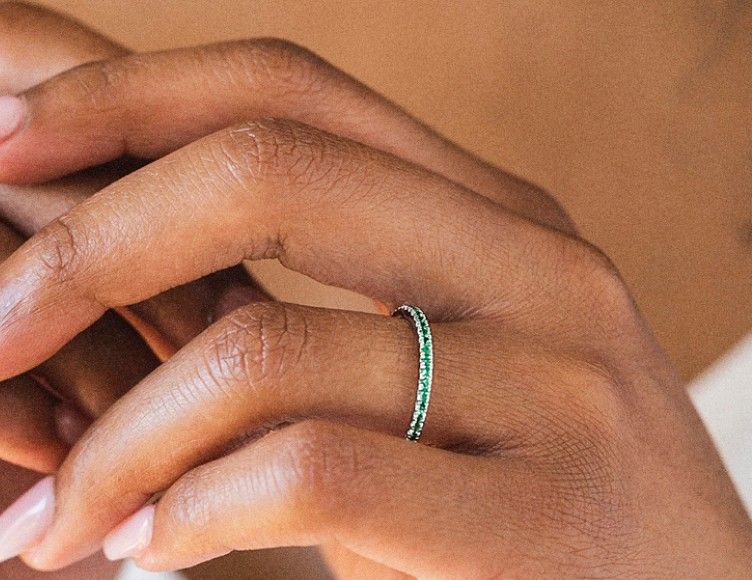 Model wearing gemstone wedding ring.