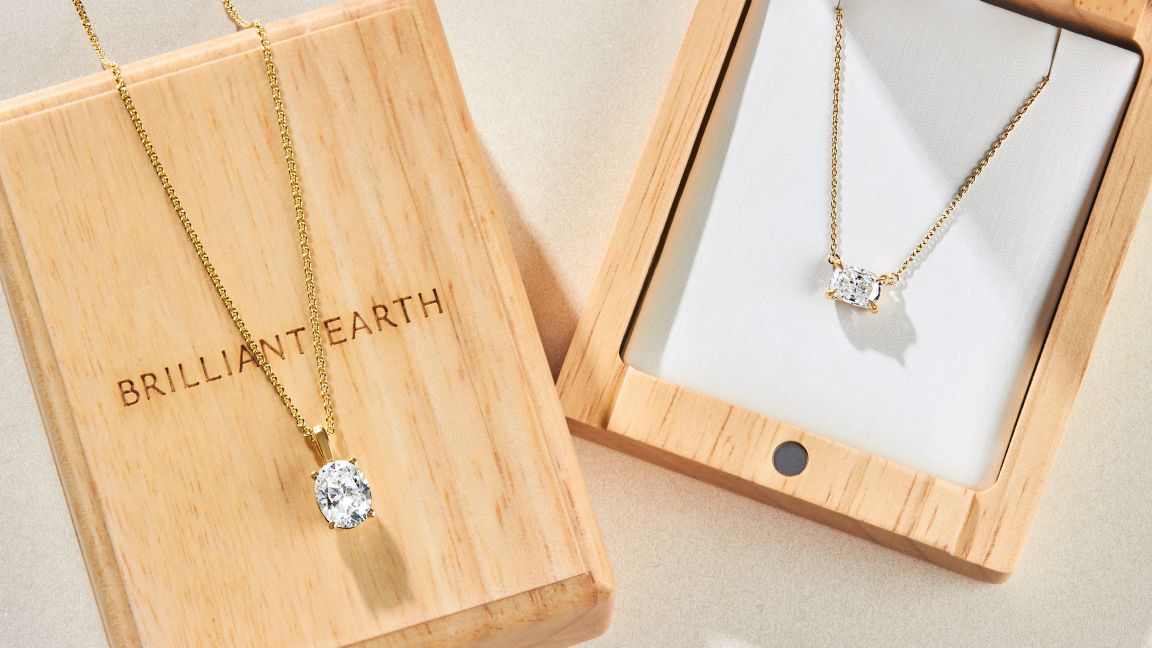 Assortment of diamond yellow gold necklaces with wooden jewelry boxes.