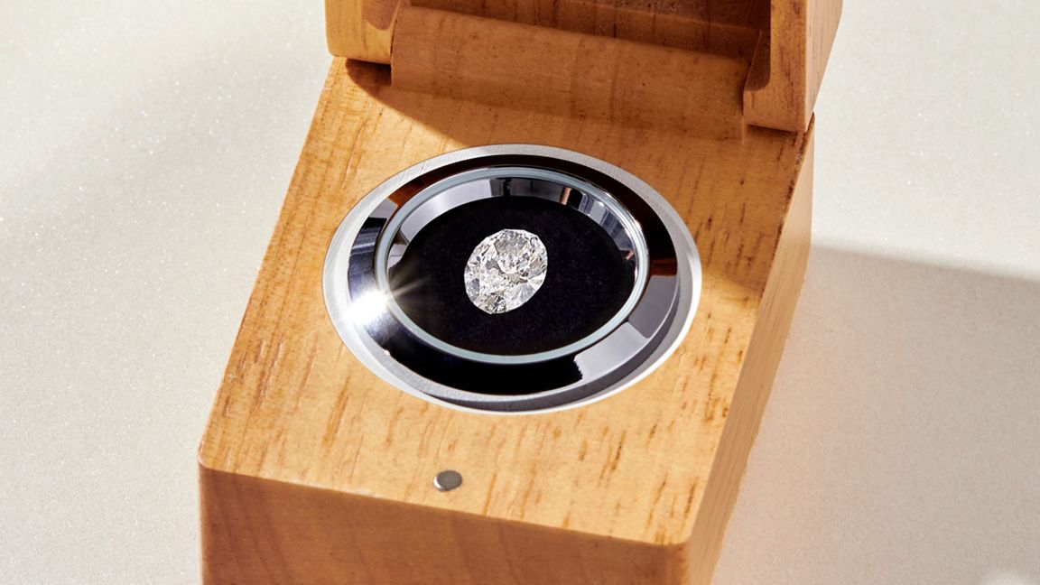 Loose oval diamond in a wooden jewelry box.