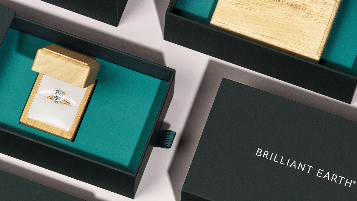 White gold engagement ring inside wooden jewelry box.
