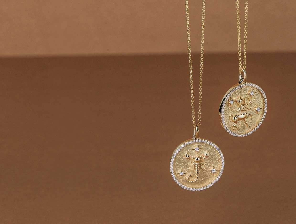 Two yellow gold zodiac necklaces with diamond accents