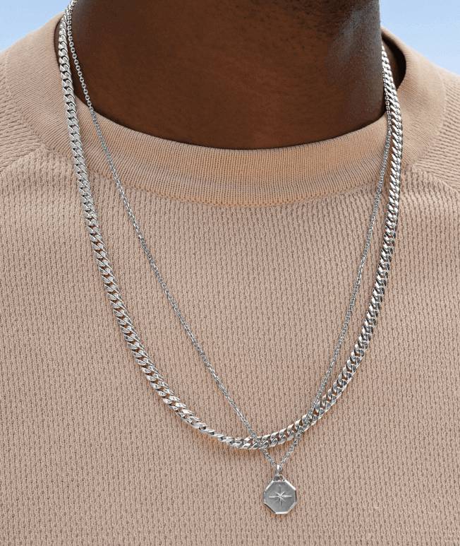 Model wearing men’s chain and medallion necklaces.