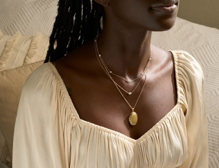 Model wearing gold diamond necklace.