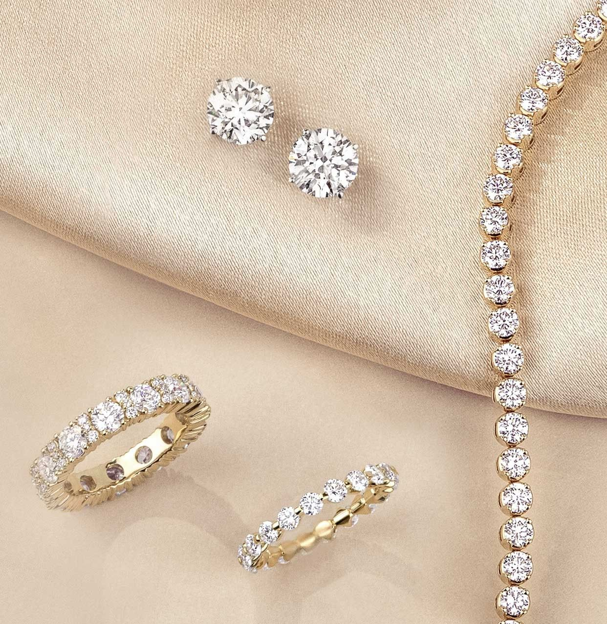 Assortment of diamond jewelry, featuring diamond rings, diamond studs, and a diamond tennis necklace