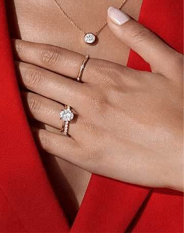 Model wearing an engagement ring and wedding ring set