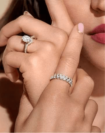 Model wearing an engagement ring paired with a contoured wedding ring