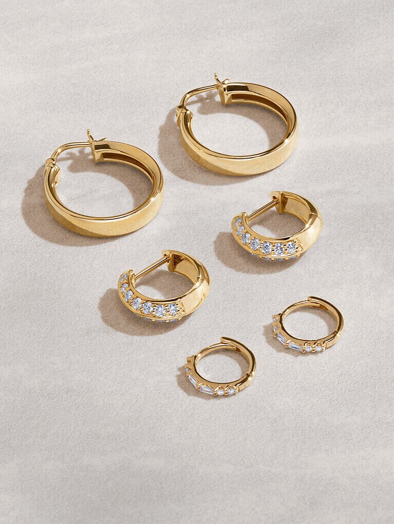 Assortment of gold, diamond hoop earrings.
