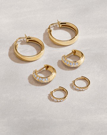 Assortment of gold, diamond hoop earrings.