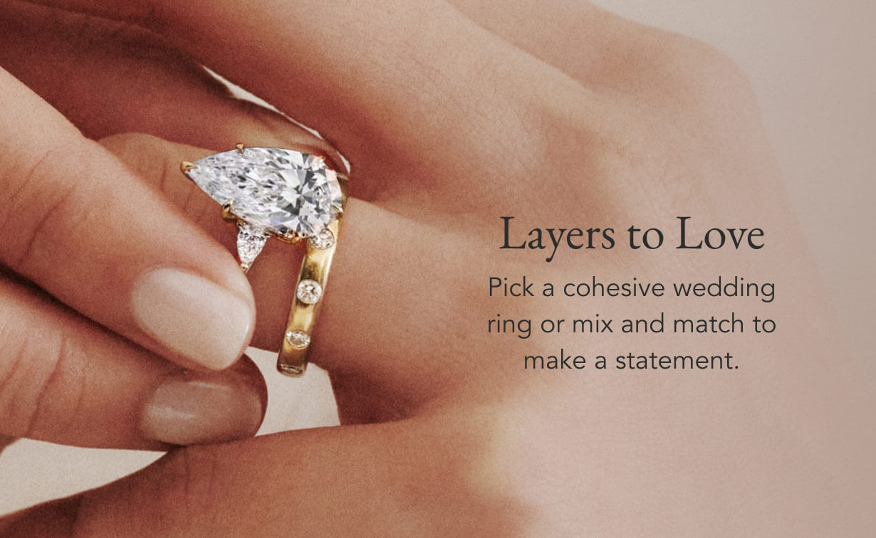 Model wearing diamond engagement ring and wedding ring.
