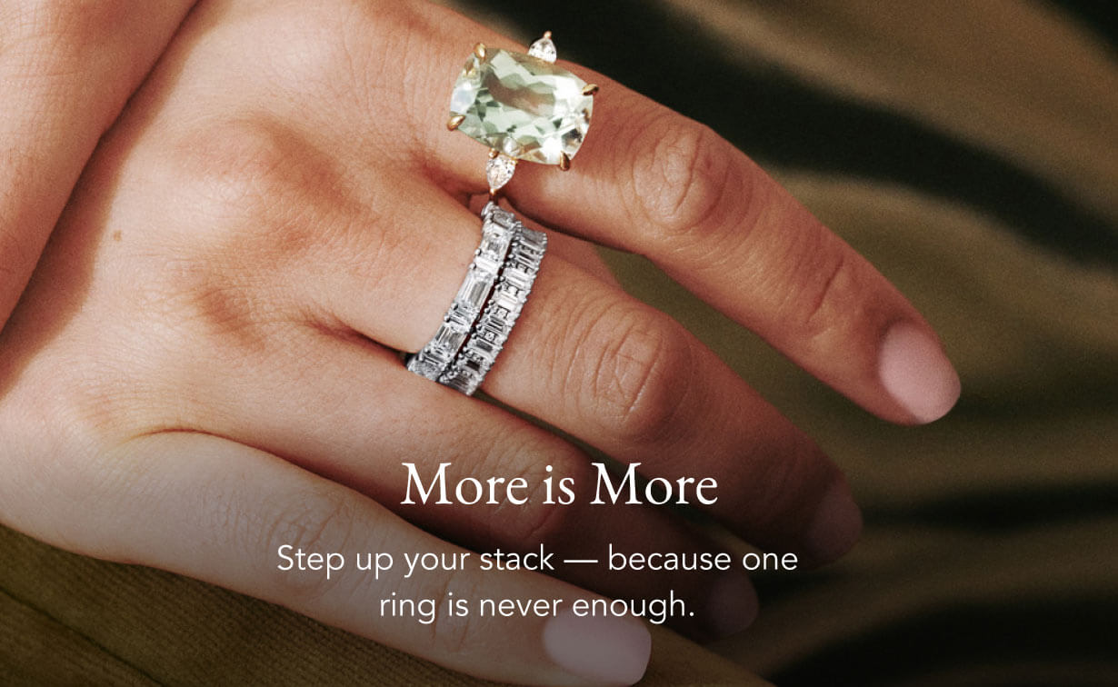 Model wearing gemstone engagement ring stacked diamond wedding rings.